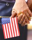 Two people holding hands and an American Flag